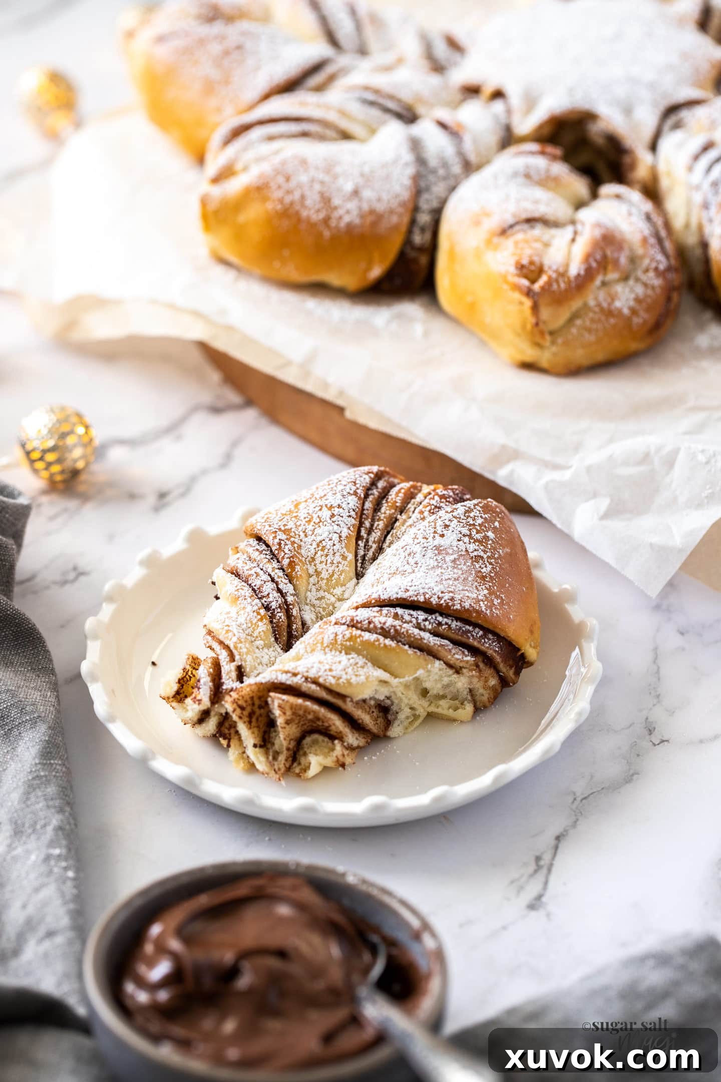 A piece of a pull apart nutella bread on a white plate, showing the flaky layers