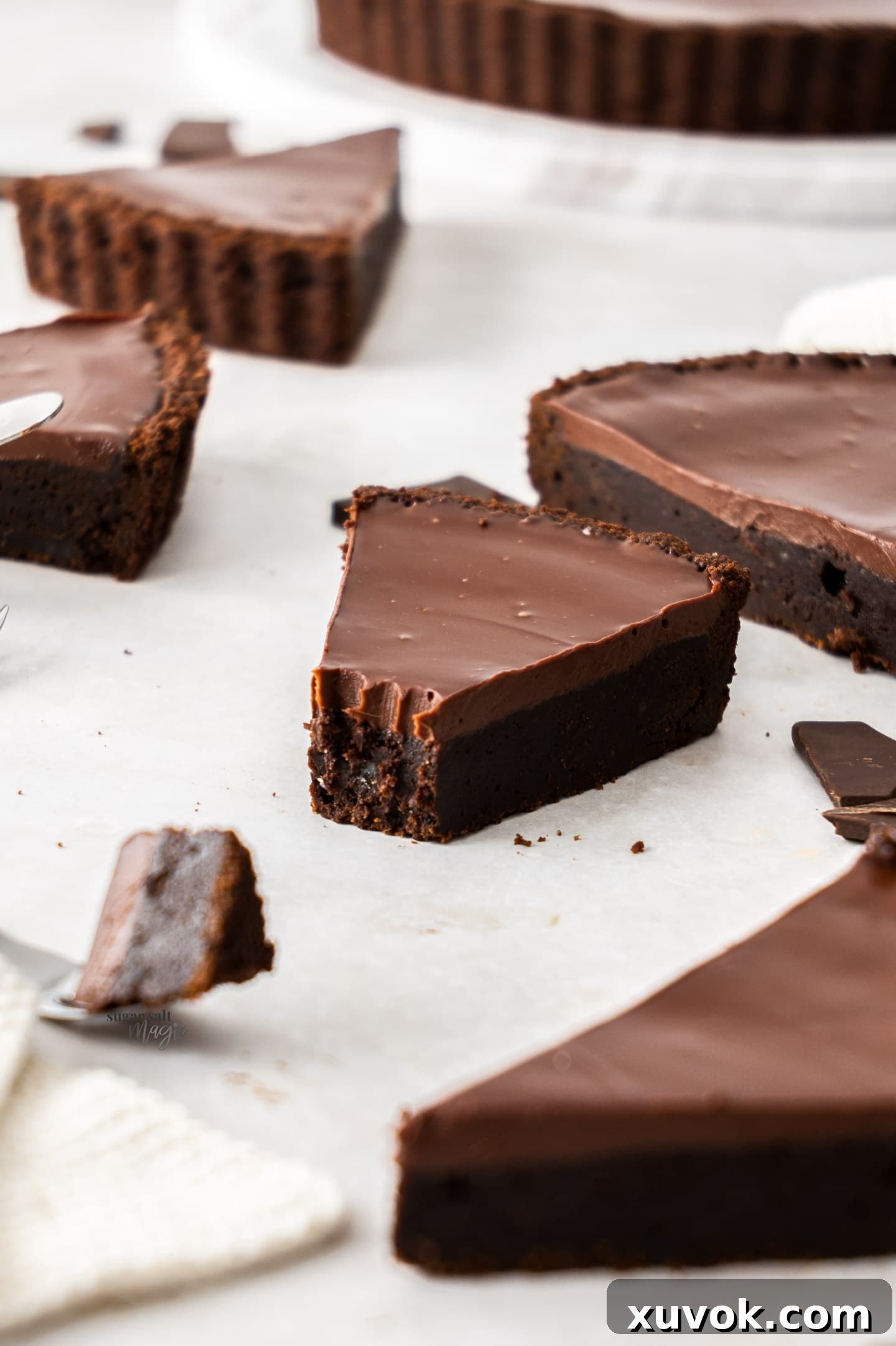 A chocolate tart displaying a few missing slices, indicating its delicious appeal.