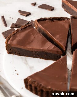 Close up of a slice of brownie tart, showcasing its rich layers.