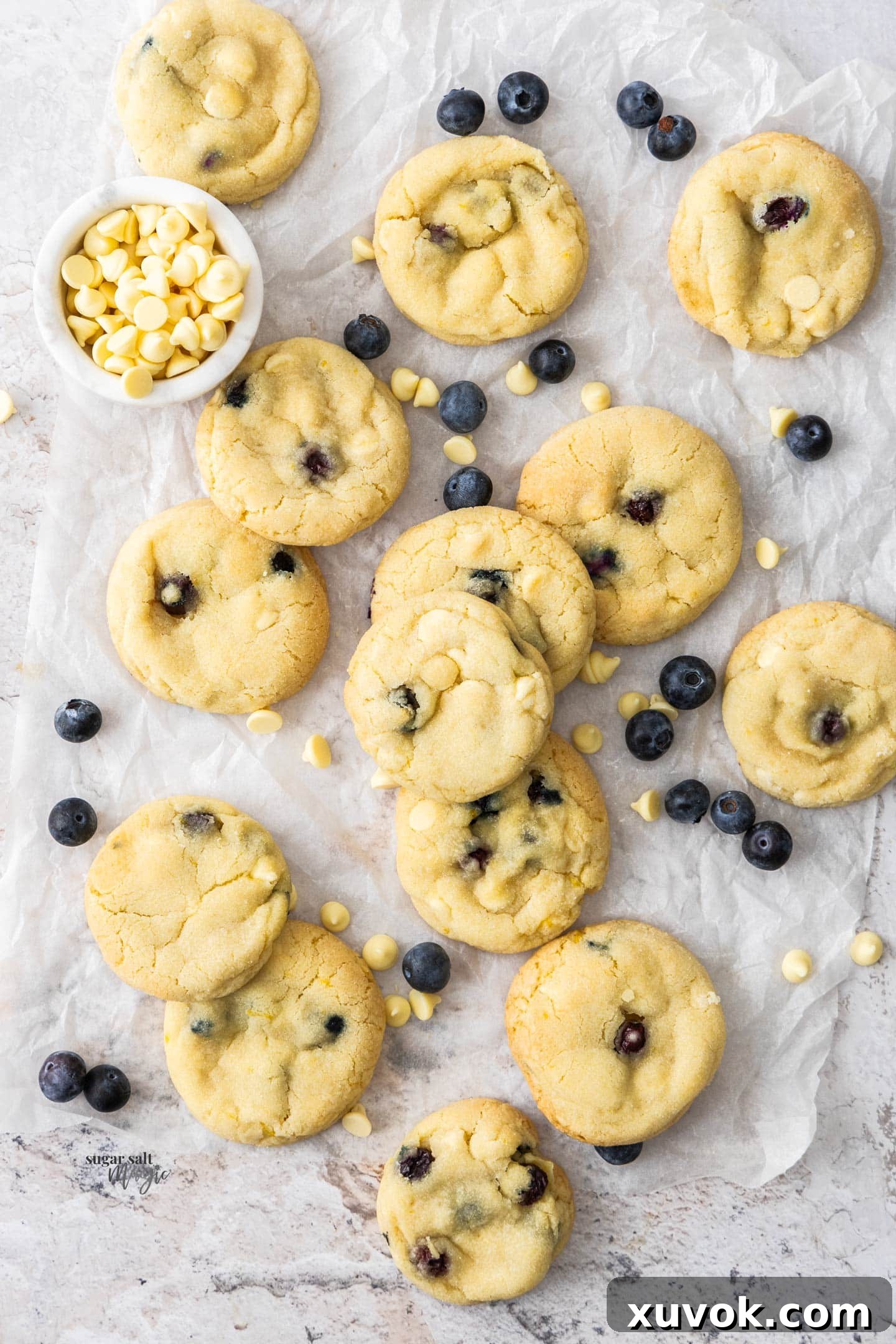 Top down view of a batch of irresistible blueberry white chocolate cookies, showcasing their plump blueberries and melted white chocolate.