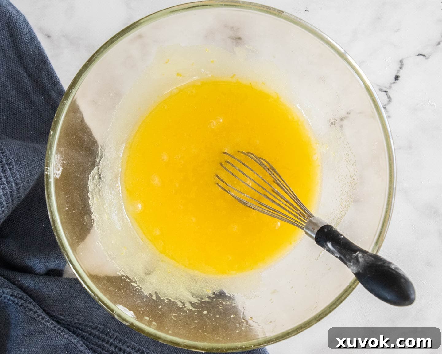 Wet ingredients and lemon sugar mixed together in a bowl, creating a smooth mixture.