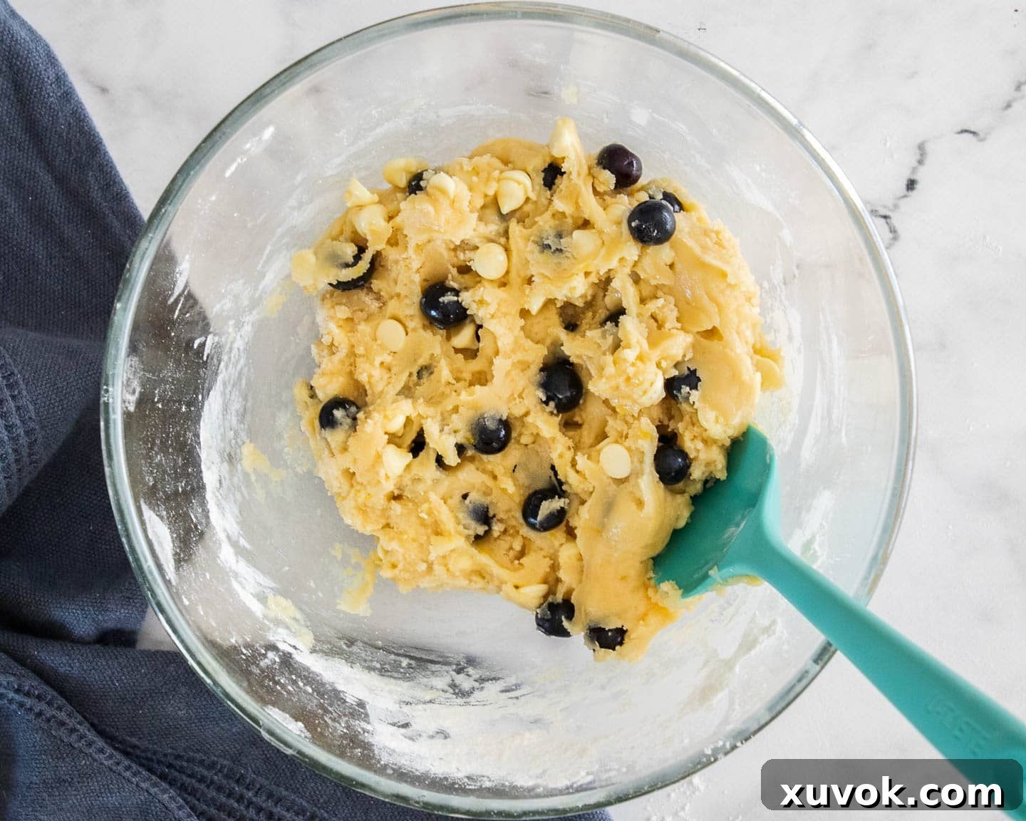 The cookie dough fully combined with blueberries and white chocolate chips.
