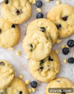 Top down view of the blueberry cookies surrounded by chocolate chips and blueberries.