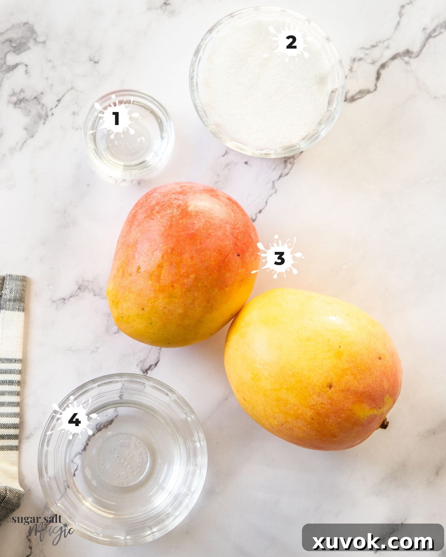 A visually appealing flat lay of the essential ingredients required for making mango sorbet, arranged on a cool marble surface.