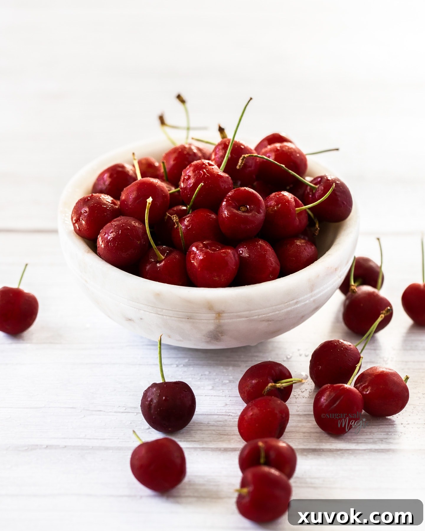 A white bowl filled with cherries