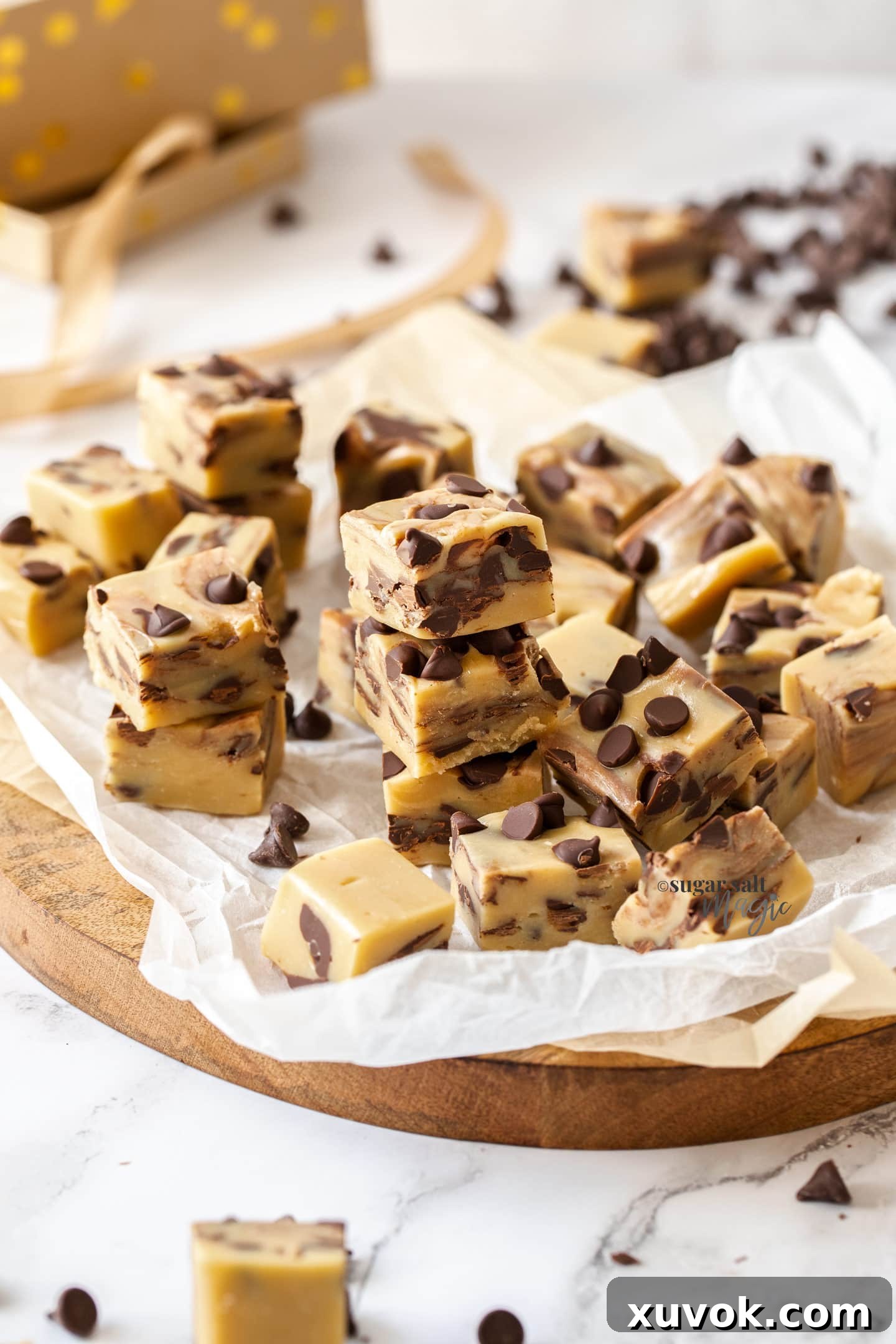 Beautifully arranged squares of Chocolate Chip Cookie Dough Fudge on a sheet of baking paper, adorned with a few extra chocolate chips, ready for serving or gifting.