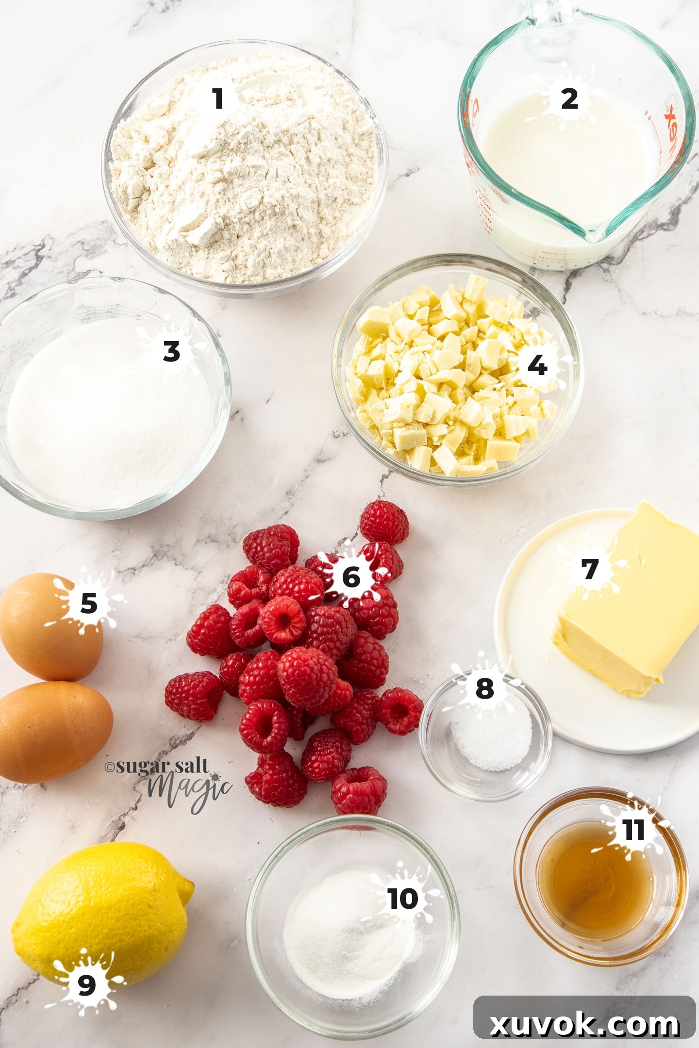 Ingredients for raspberry white chocolate muffins on a marble benchtop.