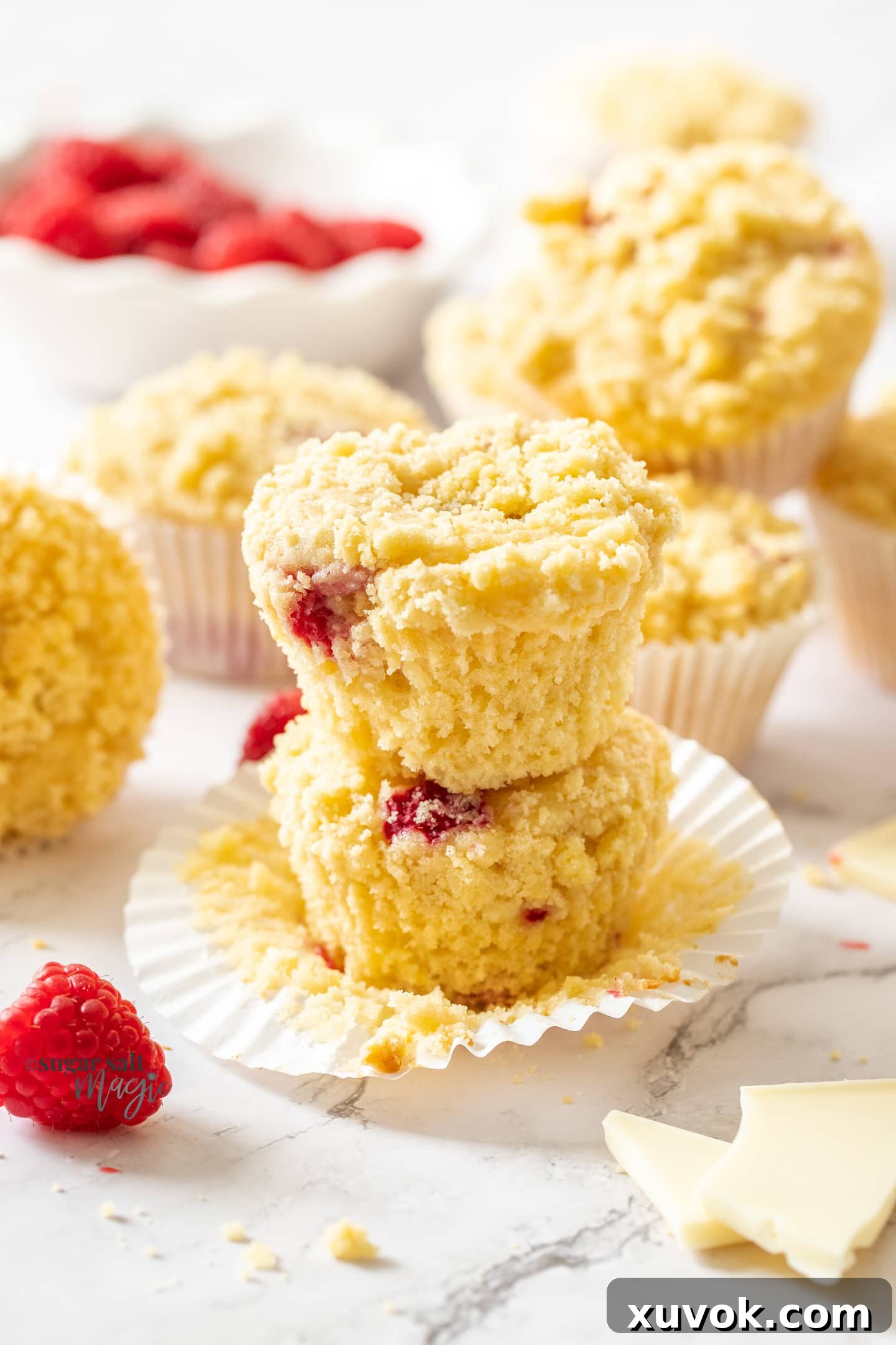 A stack of two raspberry white chocolate muffins.