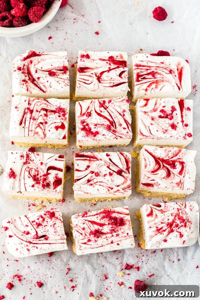 12 squares of marshmallow slice lined up on a crumpled piece of baking paper. 