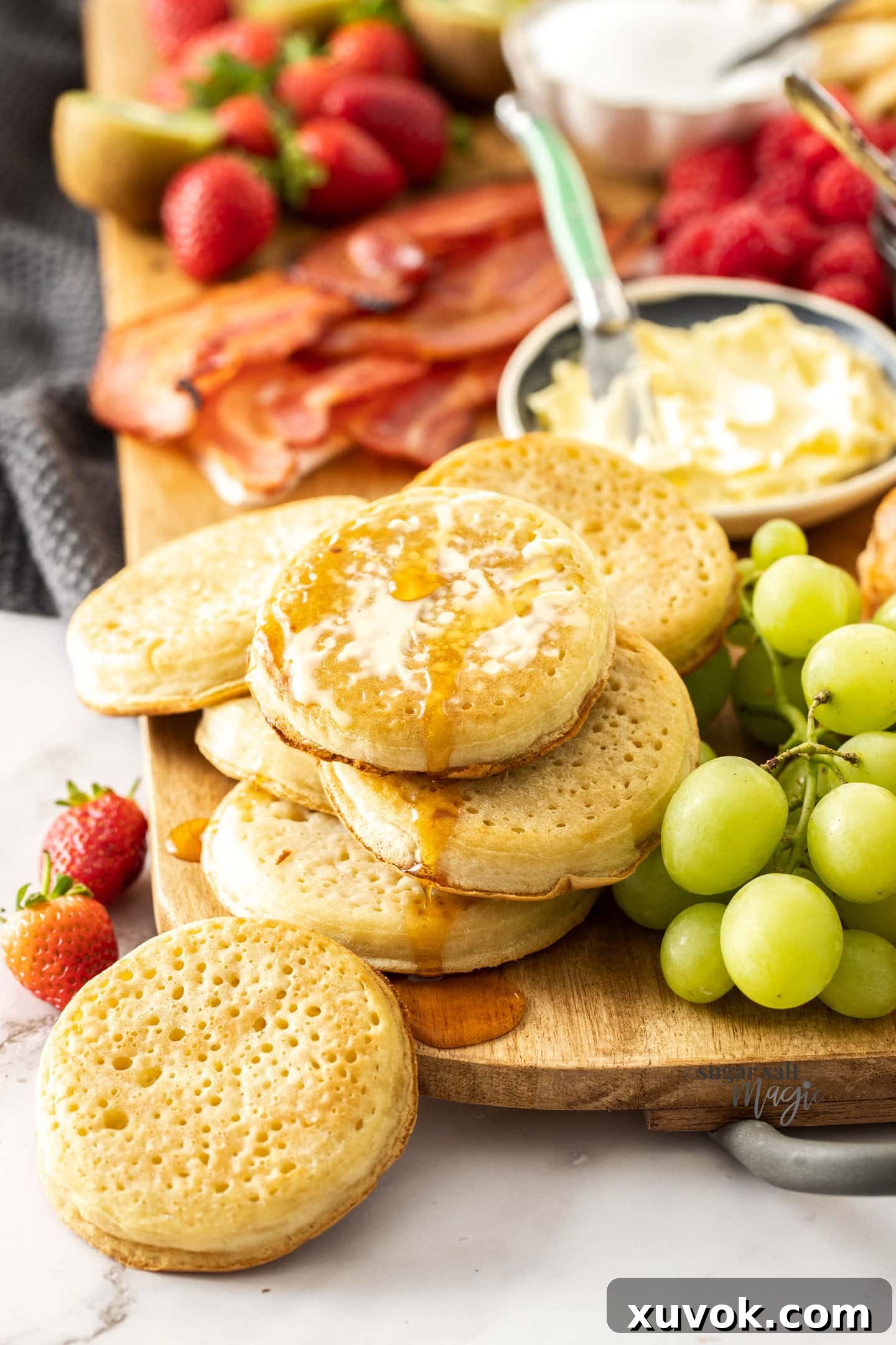 Crumpets dripping with butter and maple syrup on a breakfast charcuterie board.