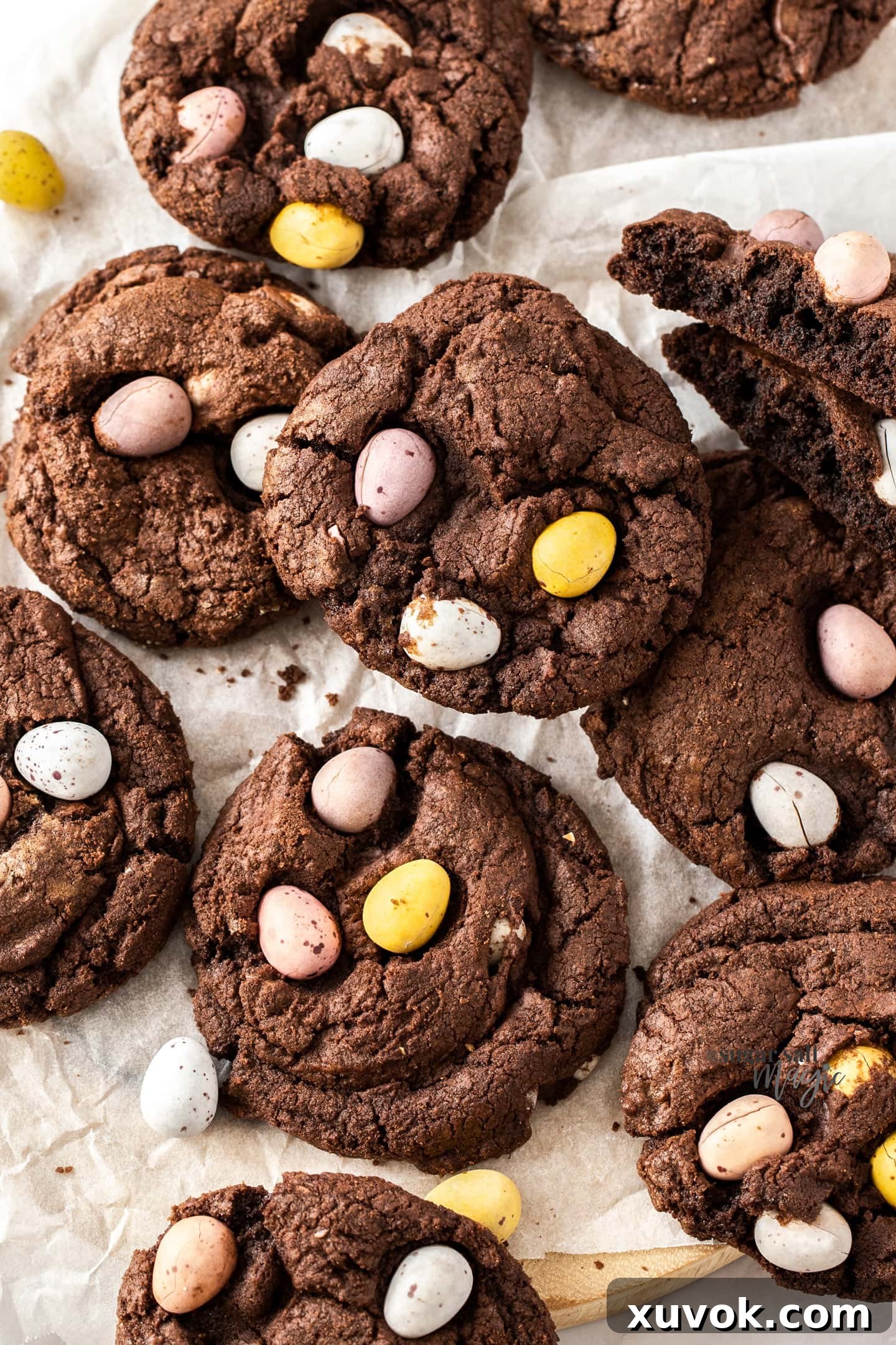 Close-up of freshly baked thick chocolate cookies studded with Cadbury mini eggs, arranged on a baking sheet.