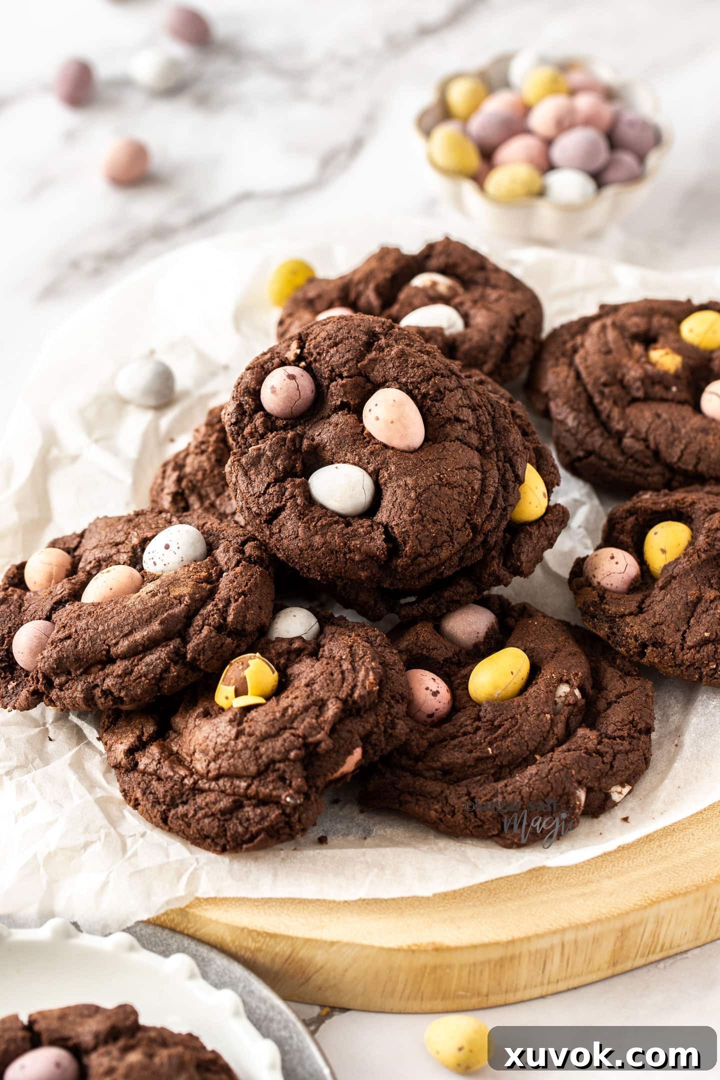 A beautiful wooden platter filled with a fresh batch of thick and fudgy chocolate mini egg cookies, showcasing their perfect texture and colorful inclusions.