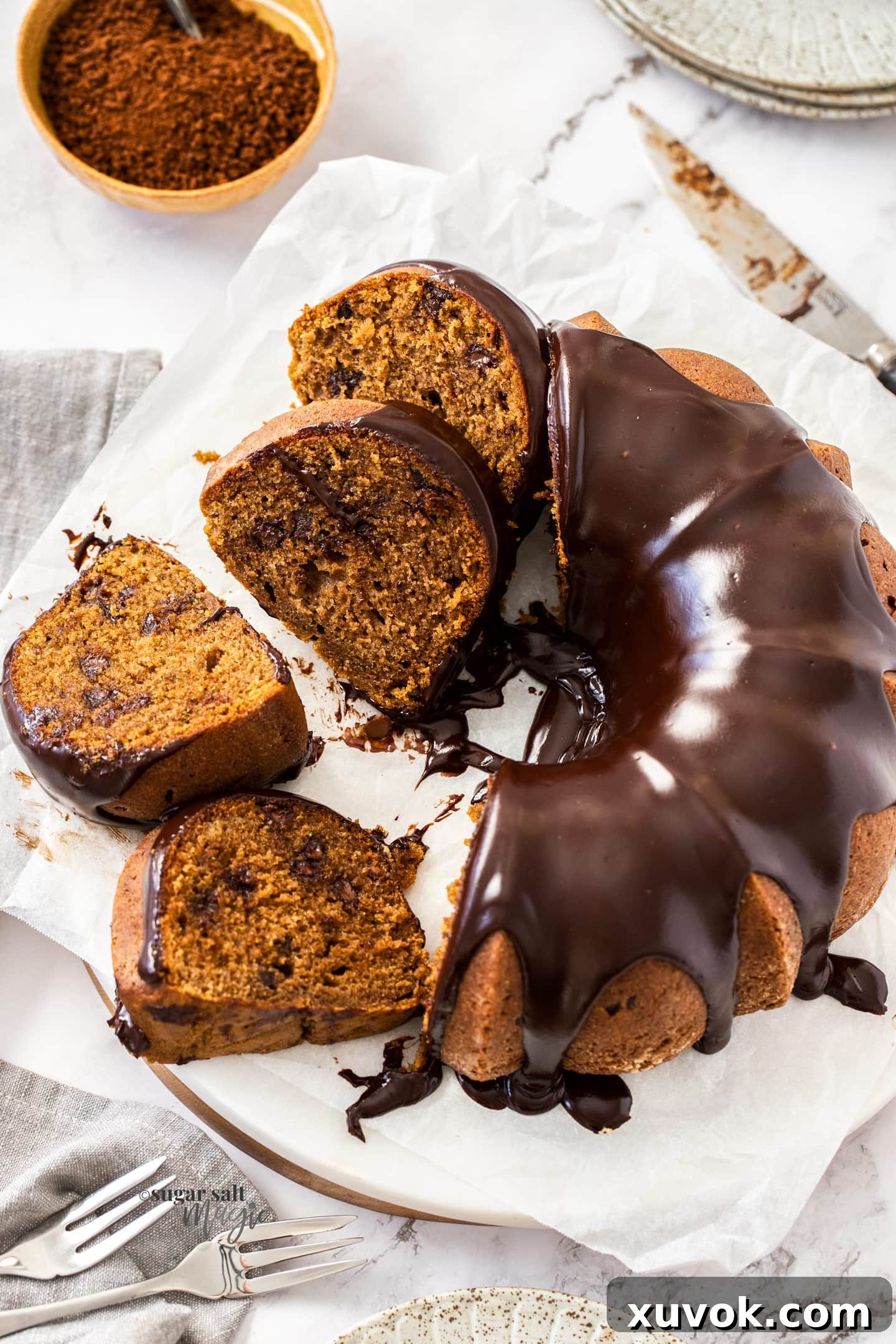 A beautifully glazed Chocolate Coffee Bundt Cake with several slices artfully arranged beside it.