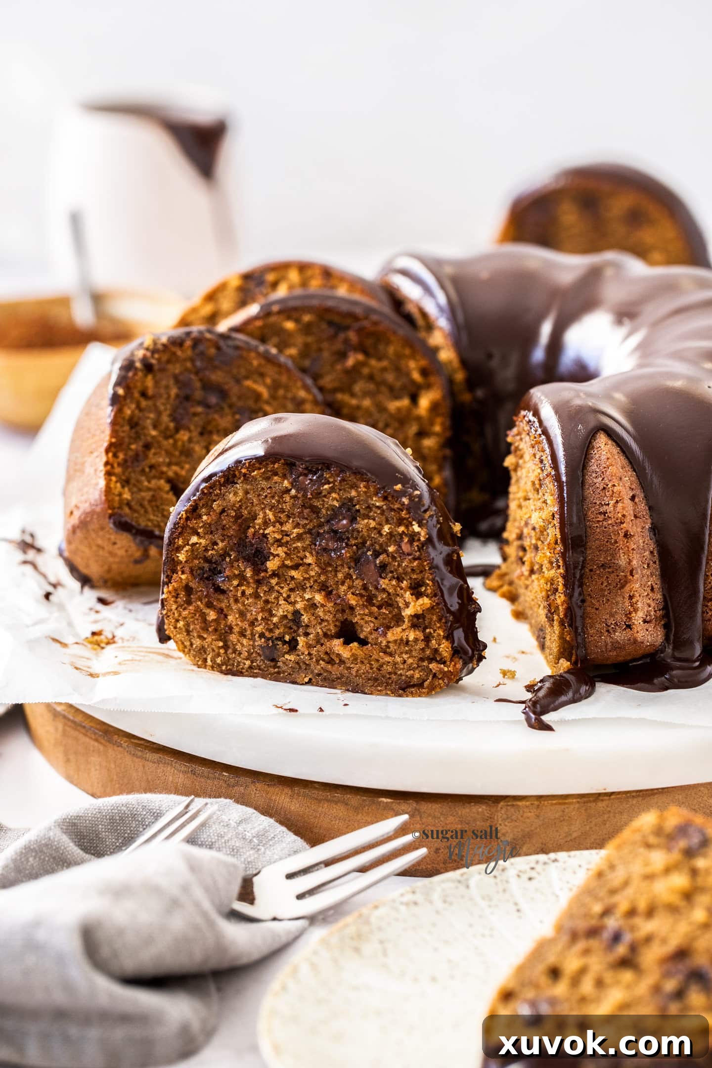 A stunning Chocolate Coffee Bundt Cake, beautifully glazed with ganache, with perfect slices ready to be served on a pristine platter.