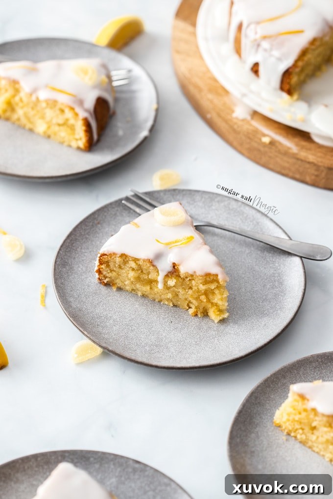 Exquisite slices of gluten-free lemon cake are elegantly arranged on sophisticated grey plates, ready to be savored.