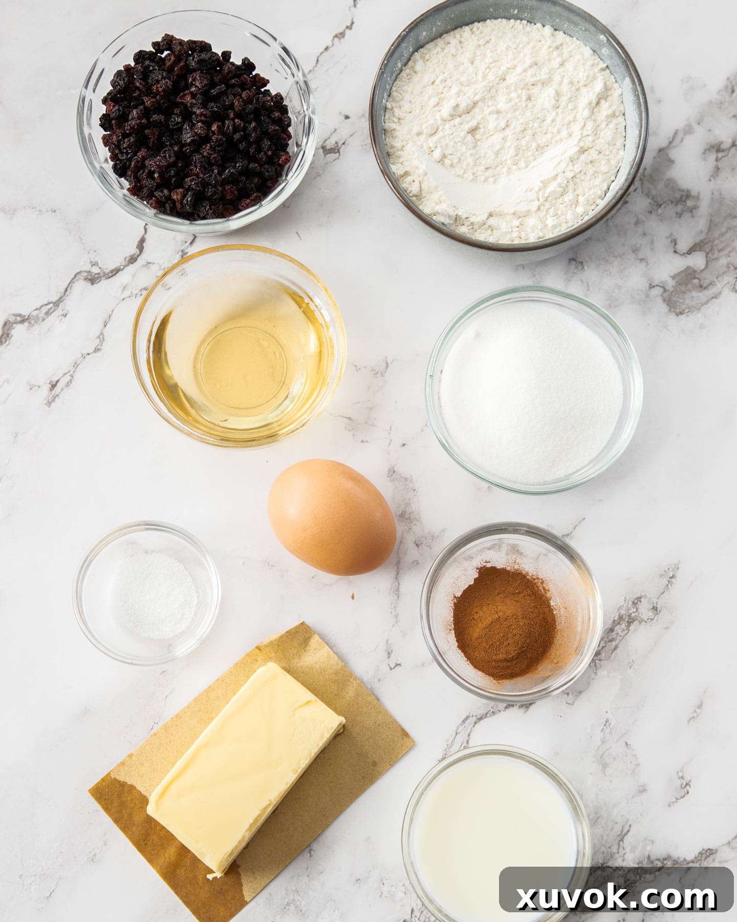 A flat lay of fresh ingredients for Garibaldi biscuits on a pristine marble countertop, highlighting the quality of components for these buttery fruit cookies.