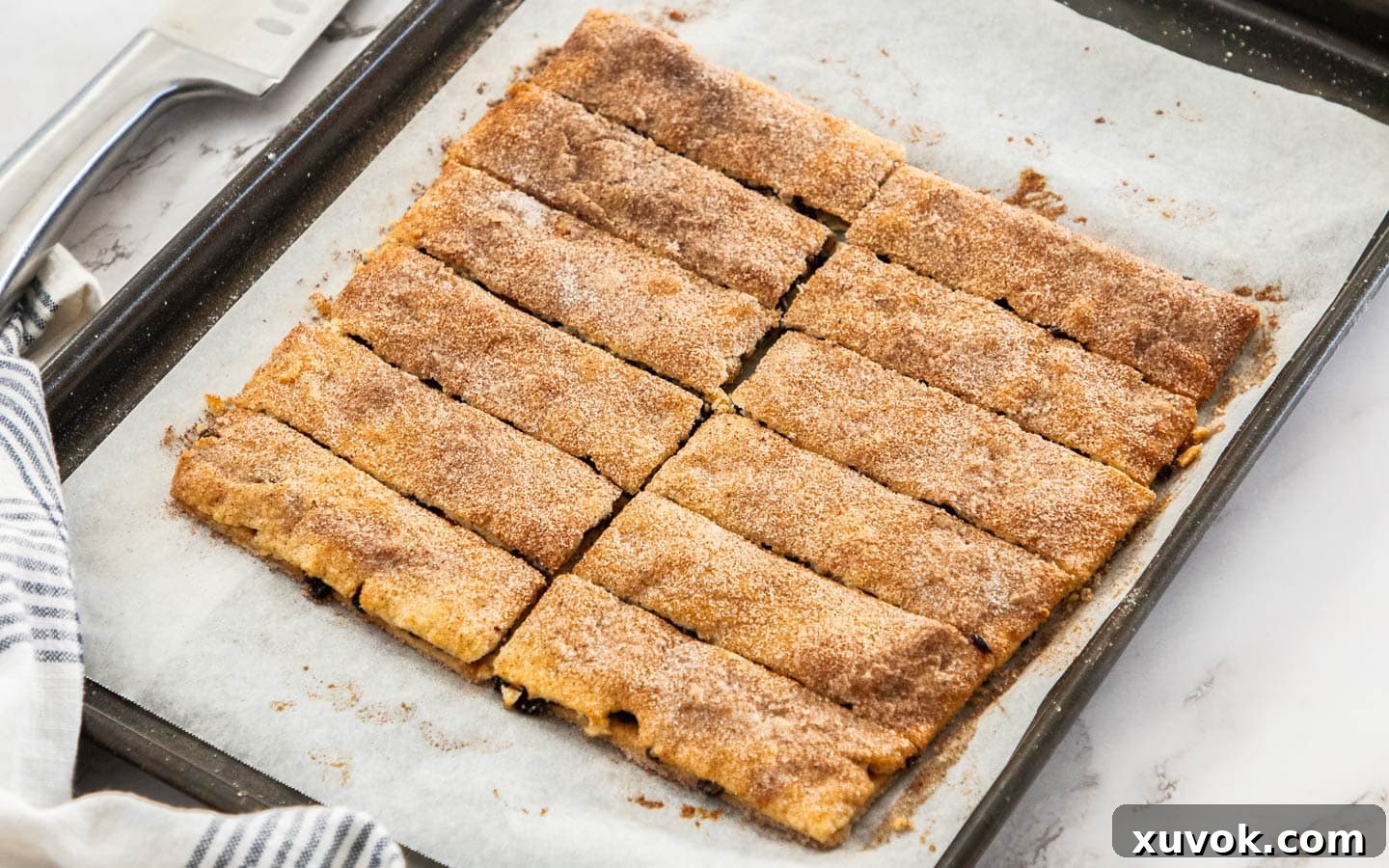 Freshly baked Garibaldi biscuits, meticulously sliced into uniform rectangles and arranged on a cooling rack, showcasing their golden crust and juicy currant filling.
