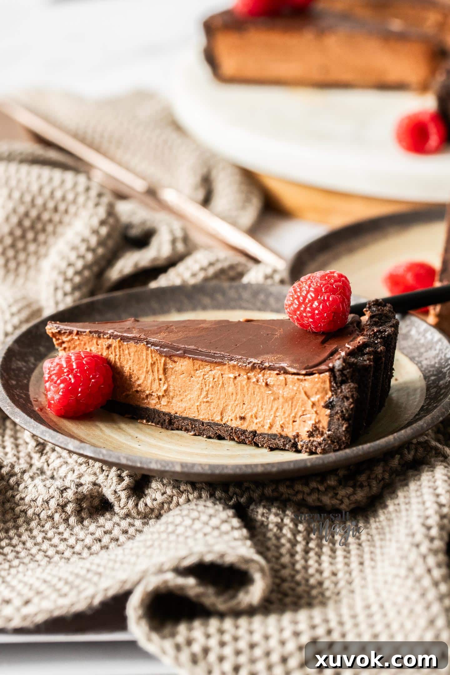A slice of choc mousse tart on a dessert plate.