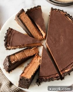 Top down view of a chocolate mousse tart with 6 slices cut.