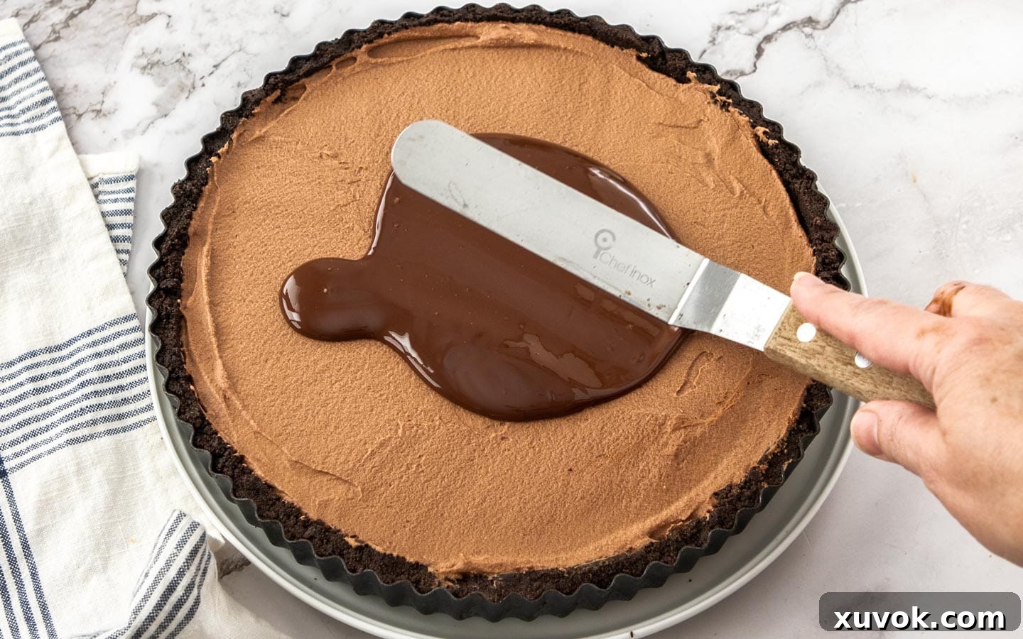 Spreading melted chocolate over the mousse layer.