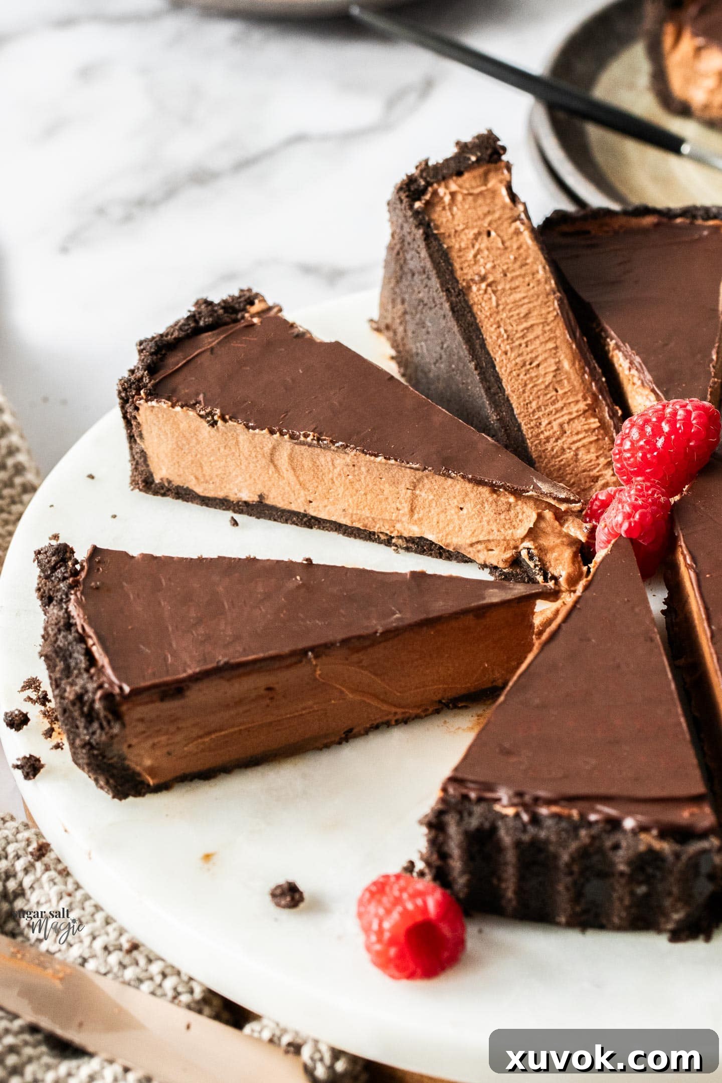 Slices of chocolate mousse tart on a marble platter.