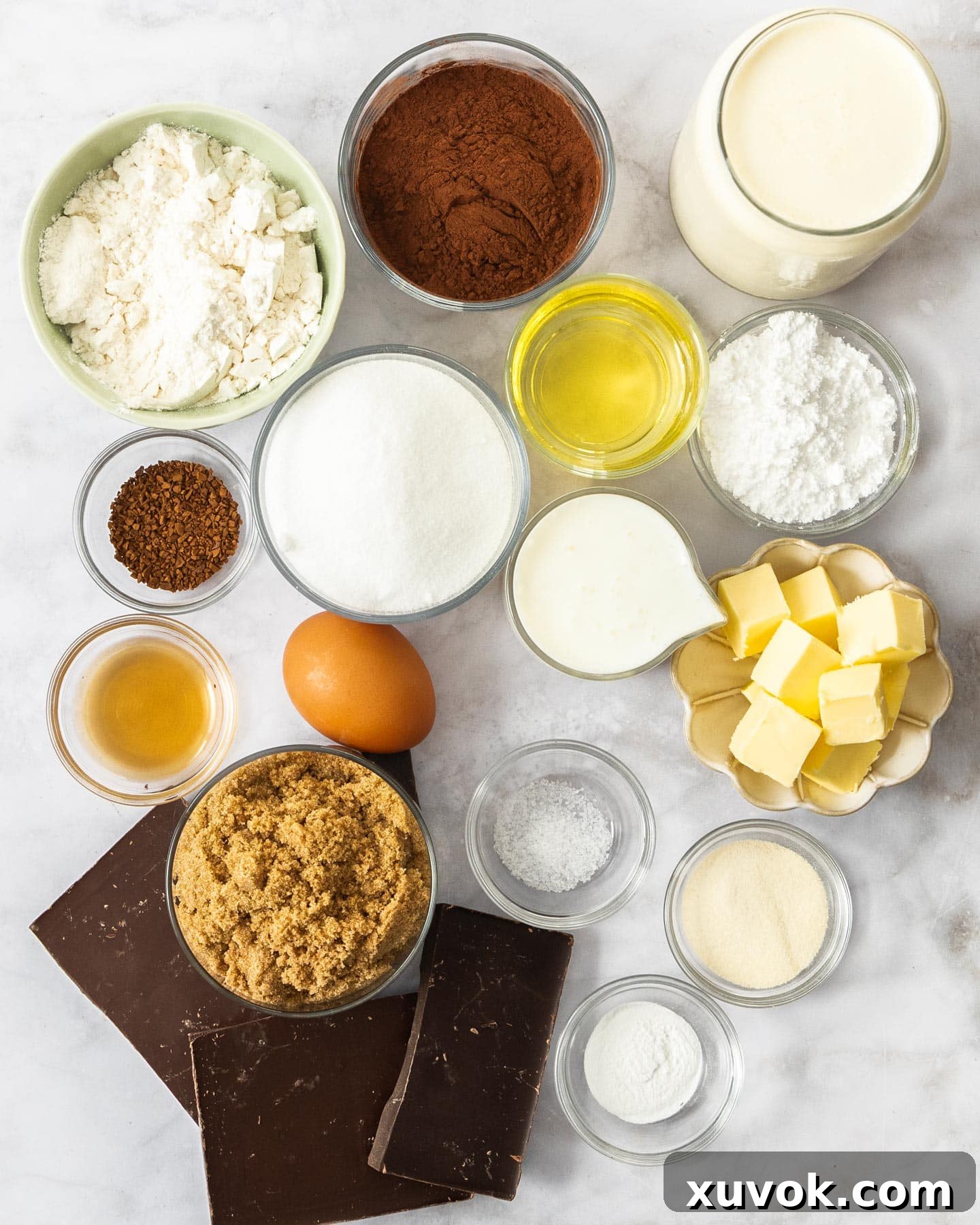 Ingredients for chocolate mousse cake on a marble surface.