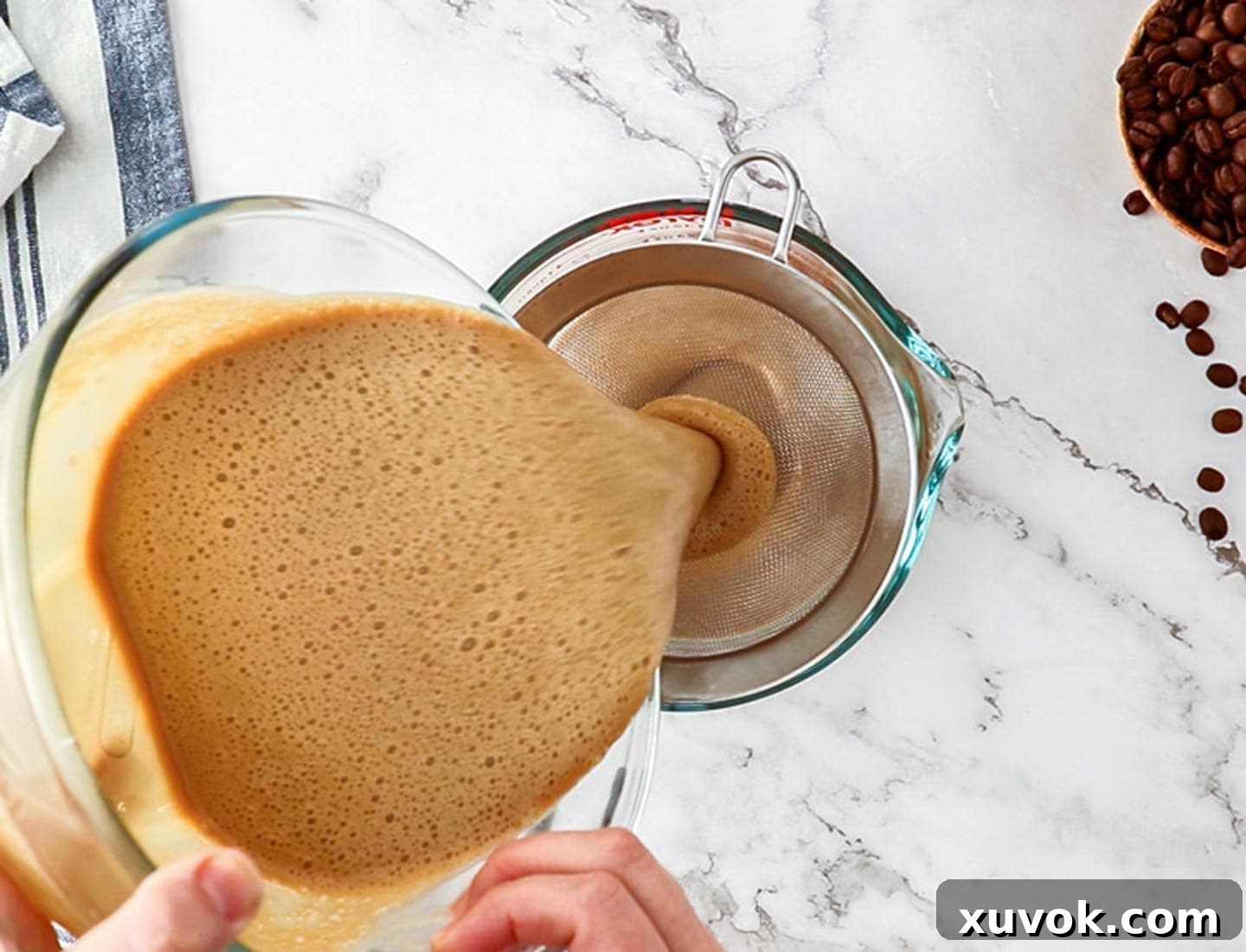 Pouring the coffee creme brulee custard through a sieve.