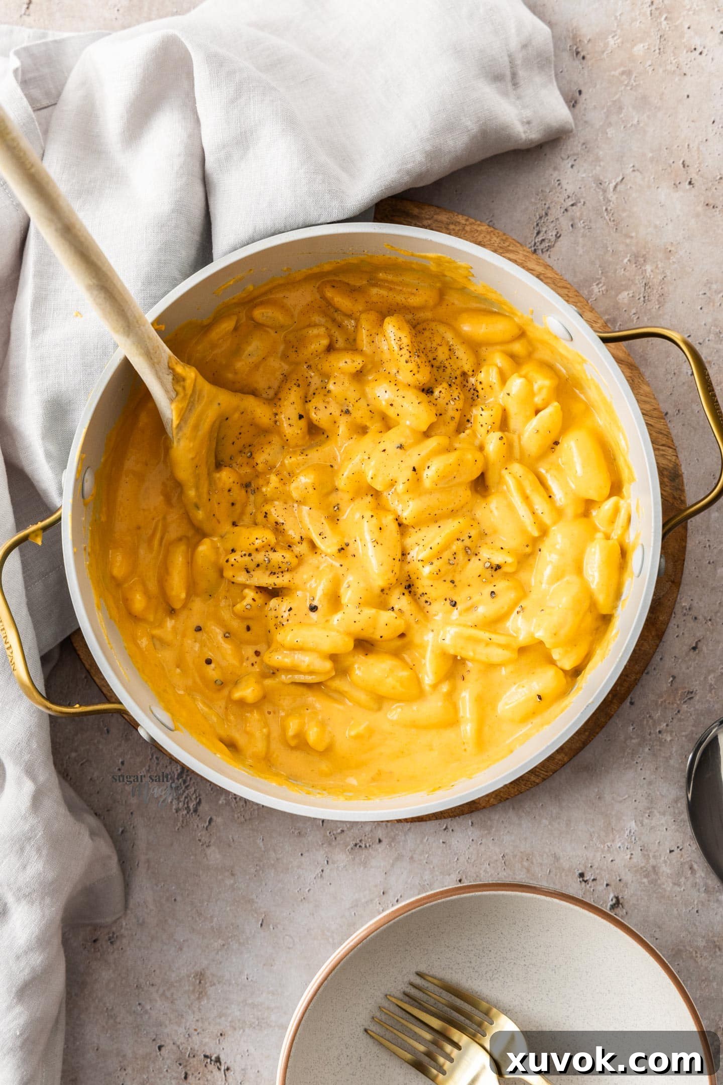 Top down view of pumpkin mac n cheese in the cooking pot on a stone surface.