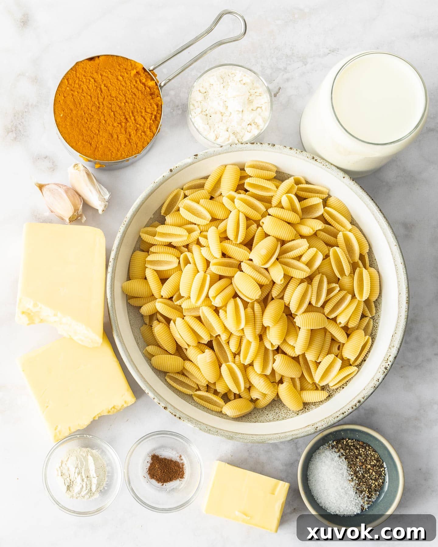 Ingredients for pumpkin mac n cheese on a marble surface.