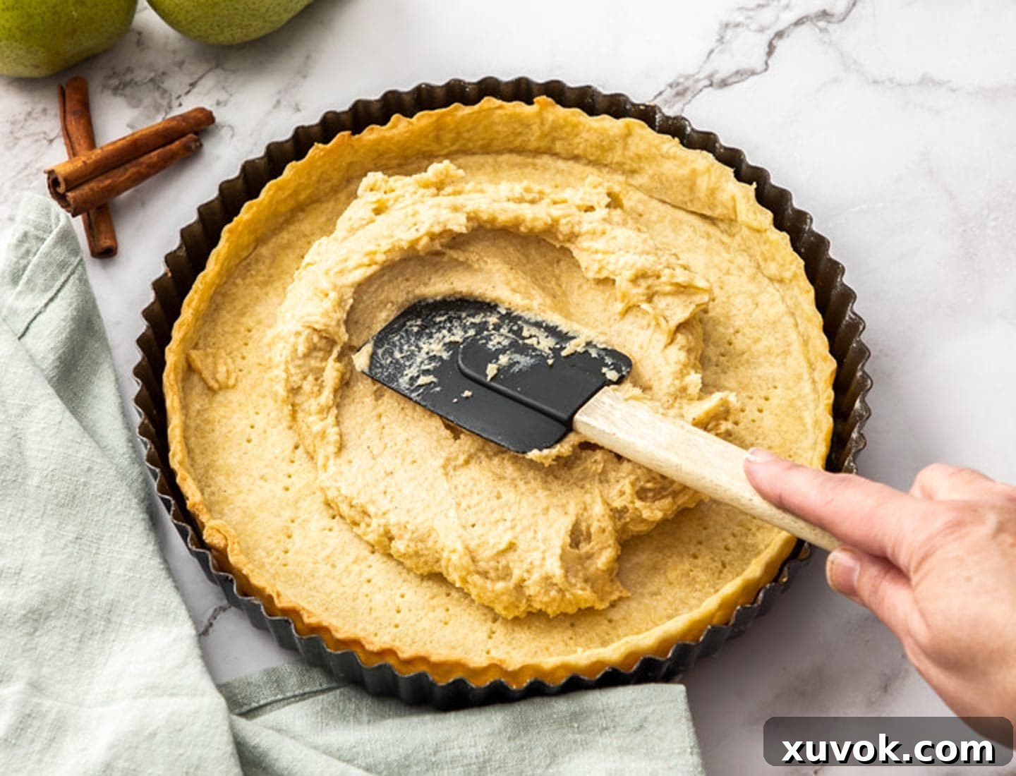 The frangipane being spread into the tart shell.