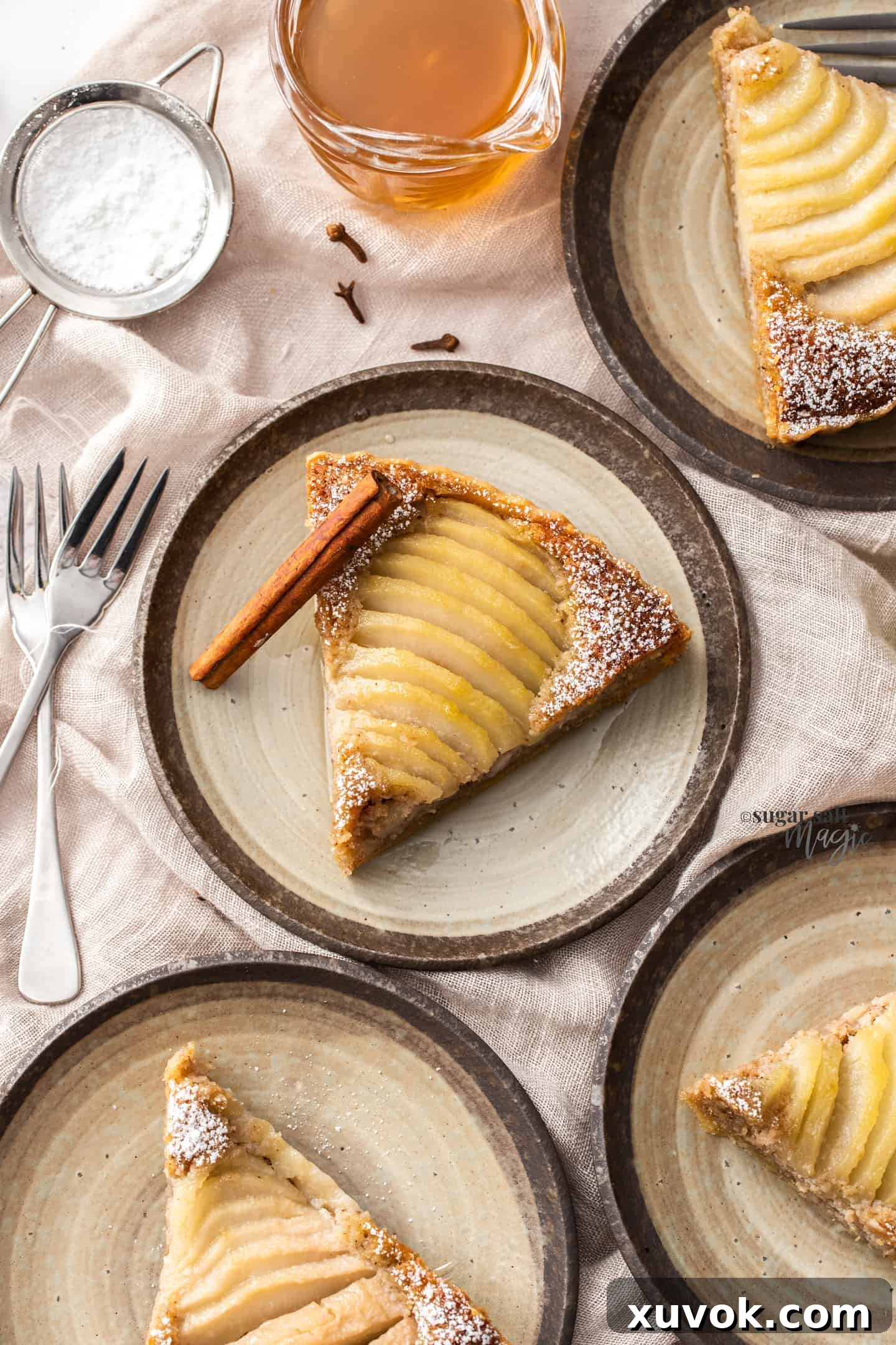 4 small cake plates, each with a slice of pear tart.