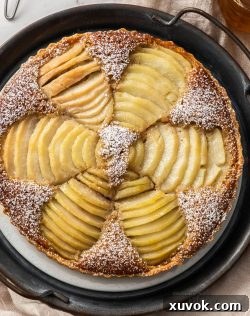 Top down view of pear frangipane tart on a metal serving tray.