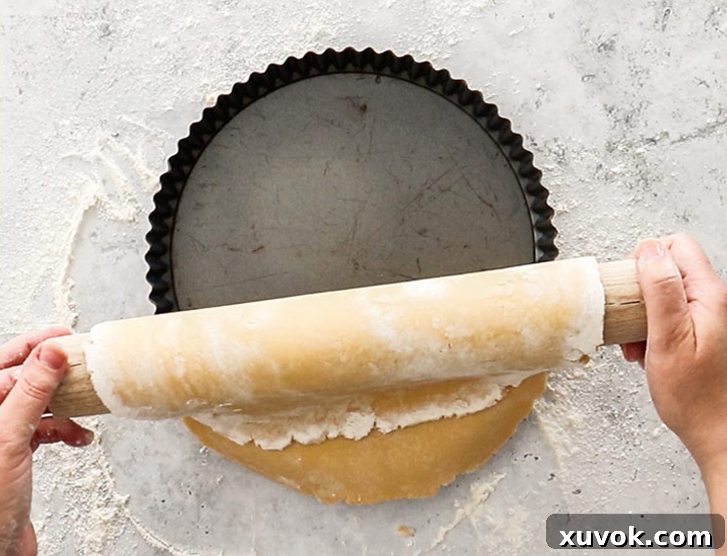 The rolled out tart dough being laid into the pan.