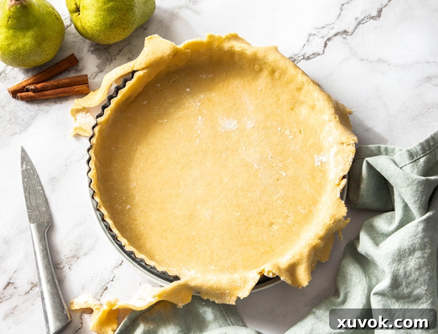 The tart shell being trimmed before baking.