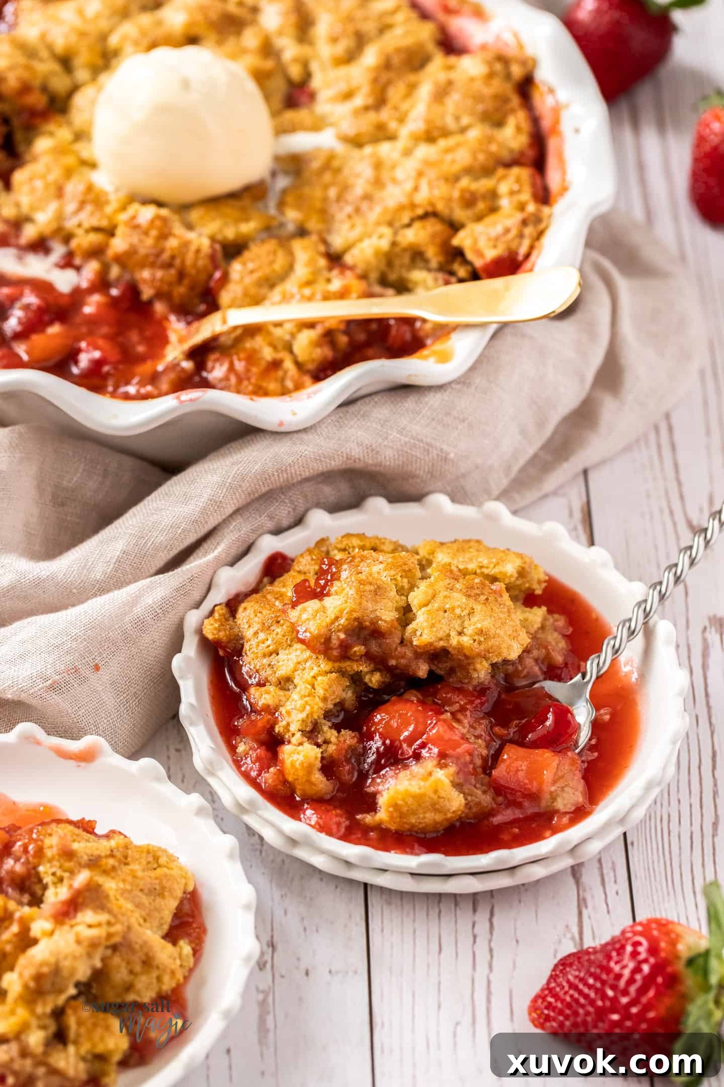 A small white dessert plate filled with strawberry rhubarb cobbler.