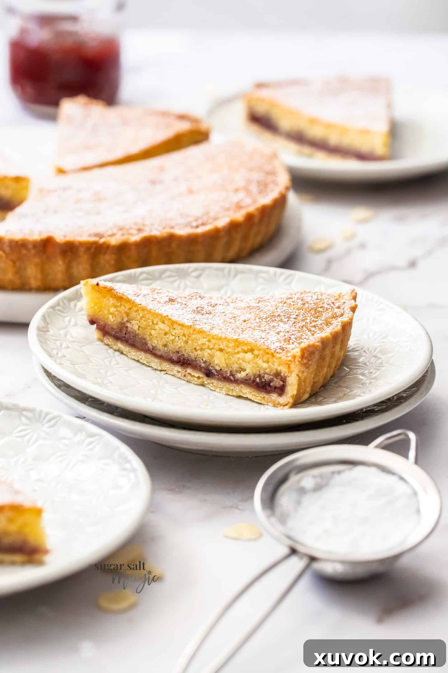 A slice of bakewell tart sitting on a white dessert plate.