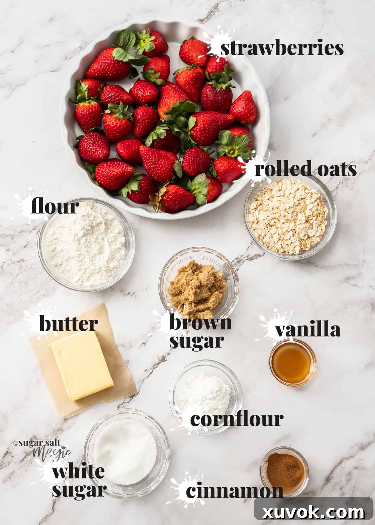 Ingredients for strawberry crisp laid out on a white marble surface.