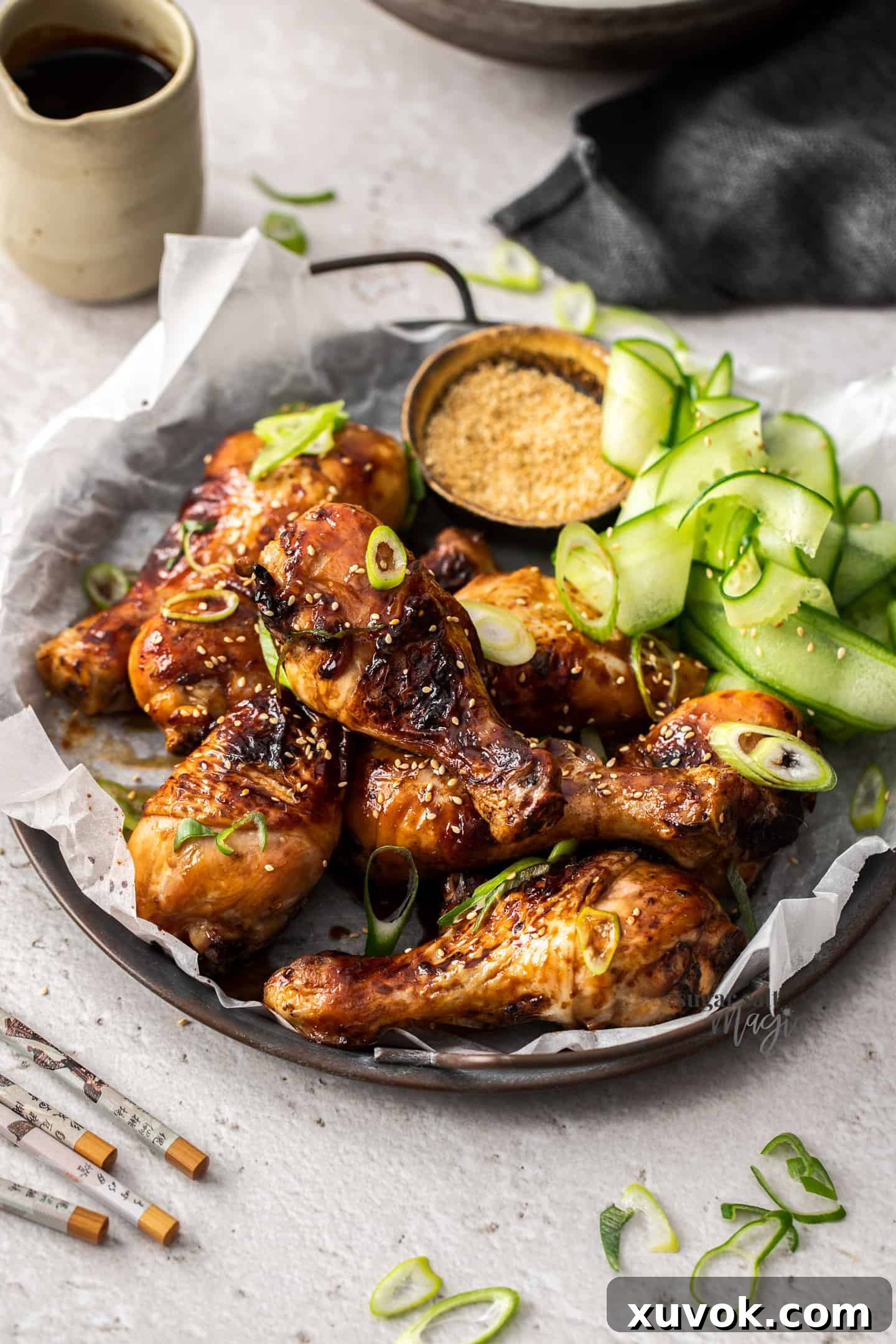 A batch of teriyaki chicken drumsticks on a metal tray ready to serve.
