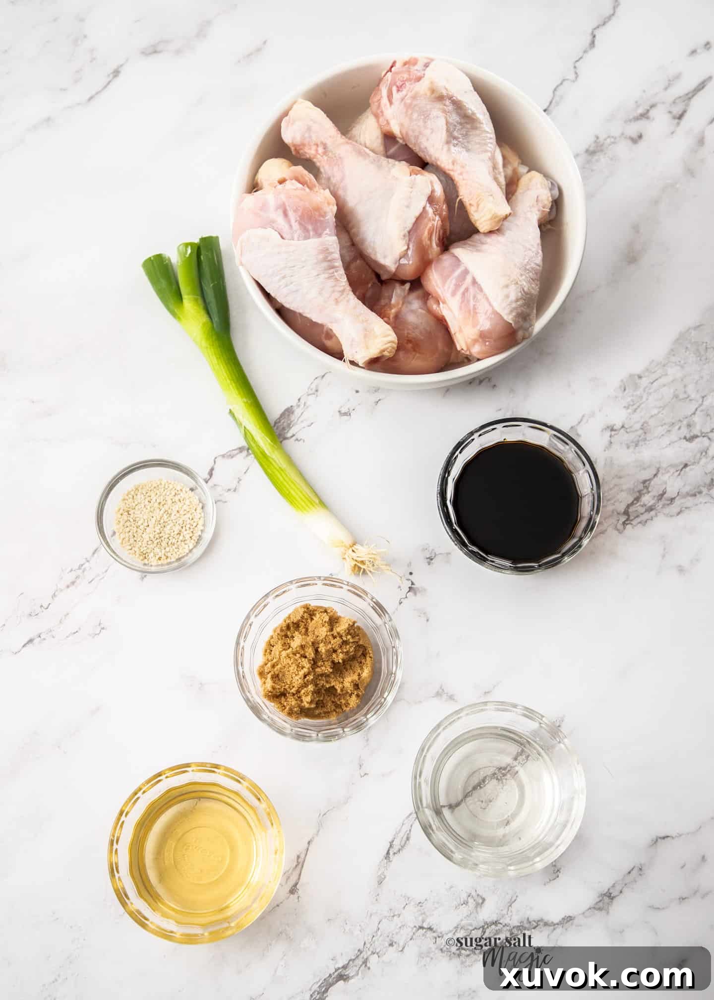 Ingredients for air fryer chicken drumsticks on a marble benchtop.