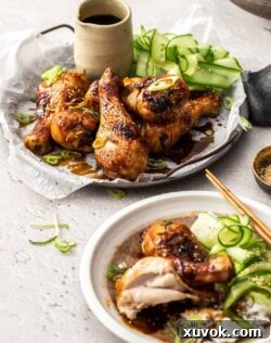 A metal tray filled with chicken drumsticks and cucumber ribbons.