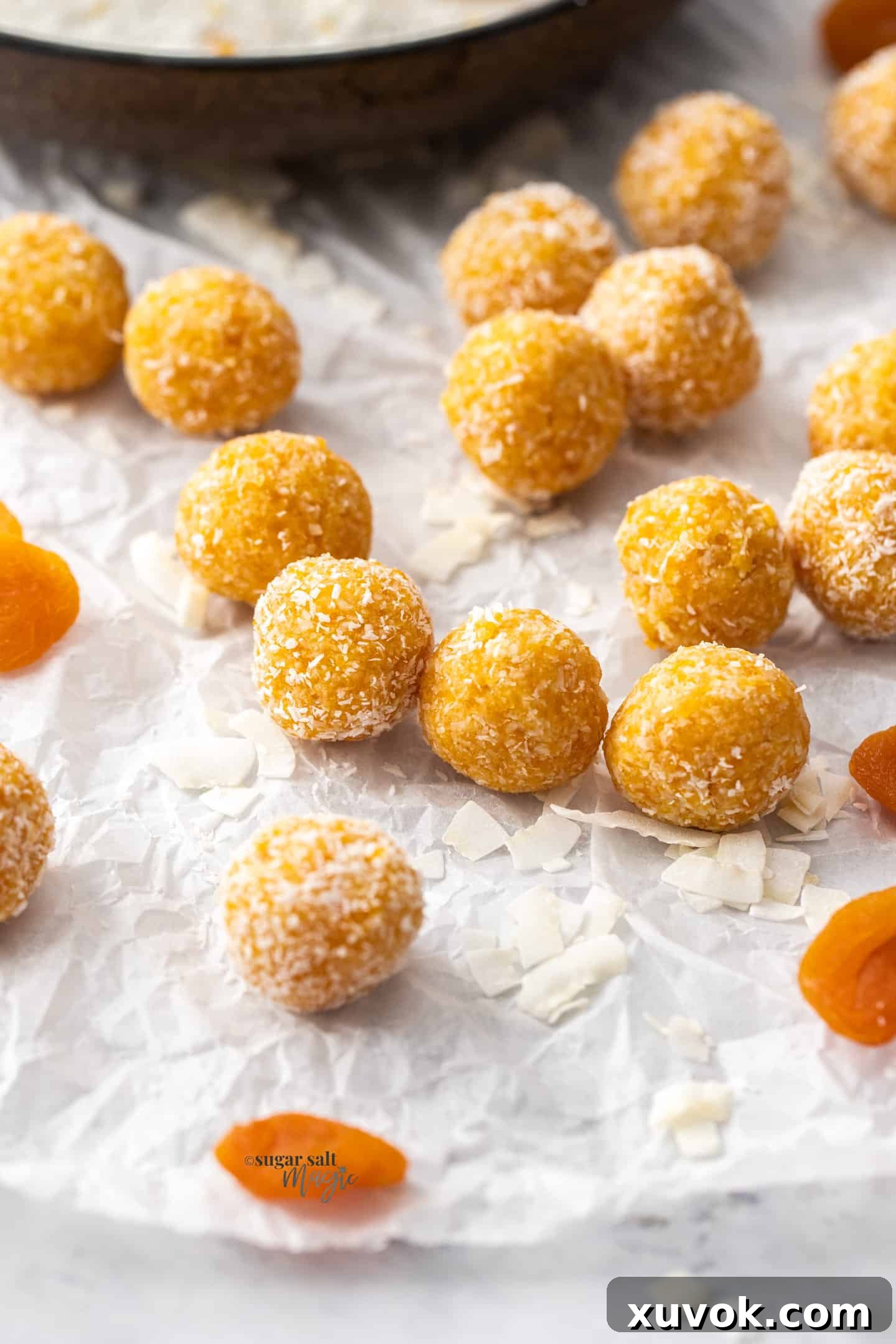 A batch of apricot bliss balls on a sheet of baking paper, highlighting their delicious and healthy appeal.