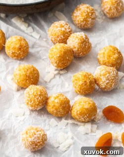 14 Apricot bliss balls on a sheet of baking paper.