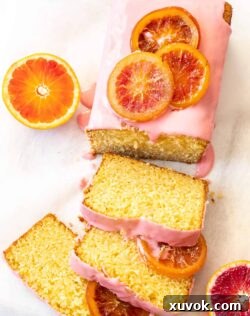 Top down view of an orange loaf cake with slices cut from it.