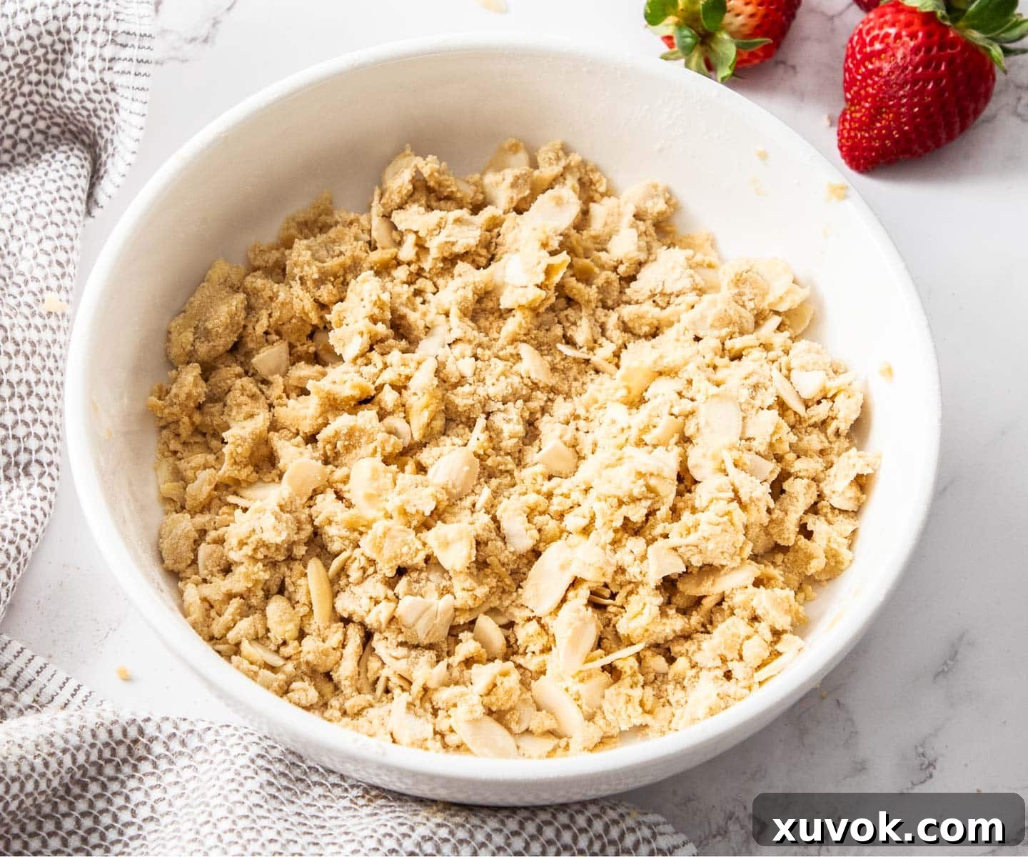 The raw crumble topping in a bowl, showing distinct clumps of butter, flour, and brown sugar.