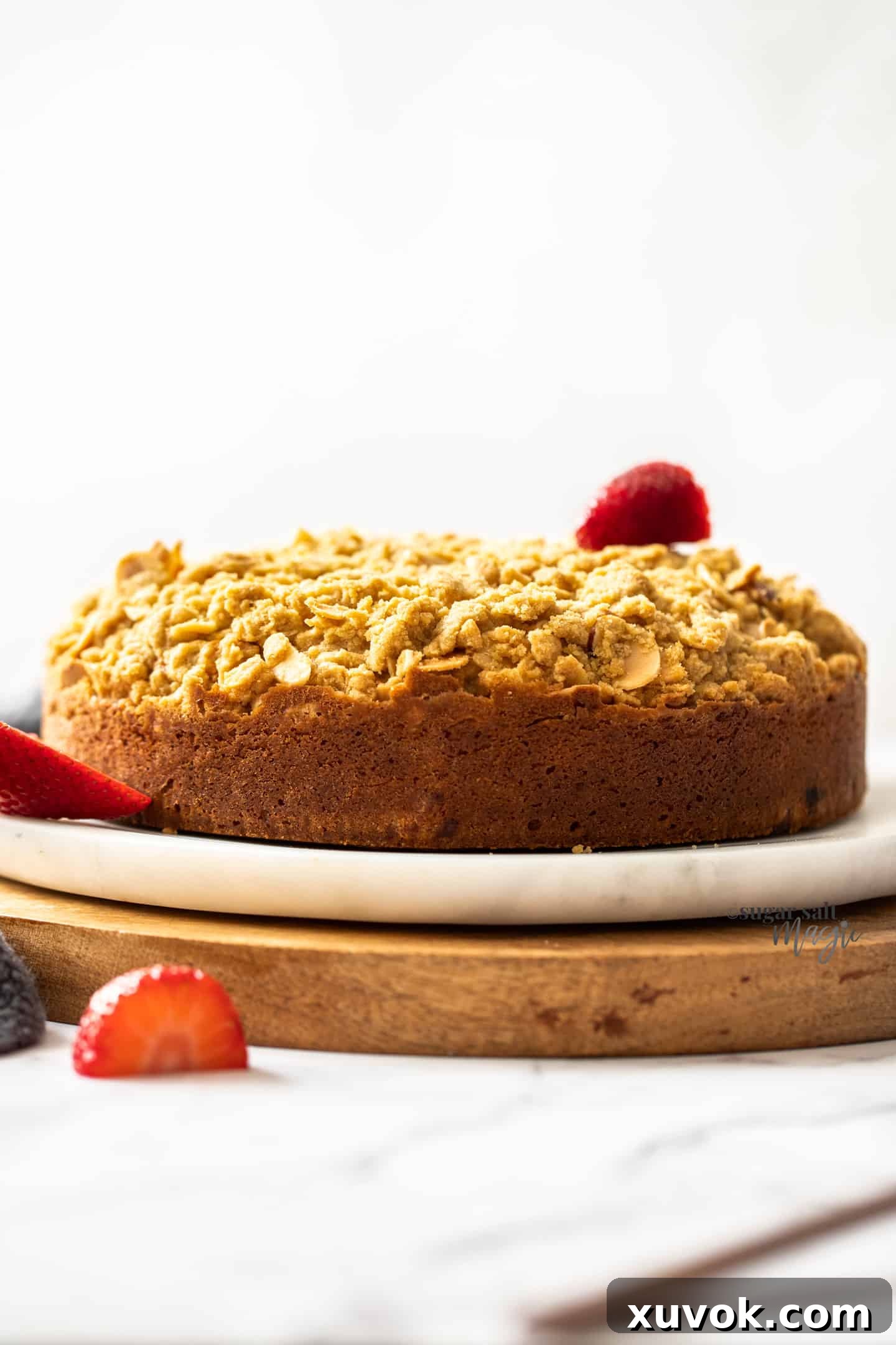 Side view of a beautiful strawberry crumb cake with a tall, crunchy crumble topping.
