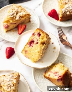 Top down view of 5 slices of strawberry crumb cake on white plates.