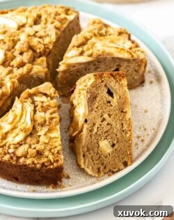 Three slices of perfectly baked Cinnamon Apple Crumb Cake neatly arranged on a taupe cake plate, highlighting the crumb topping and moist interior.