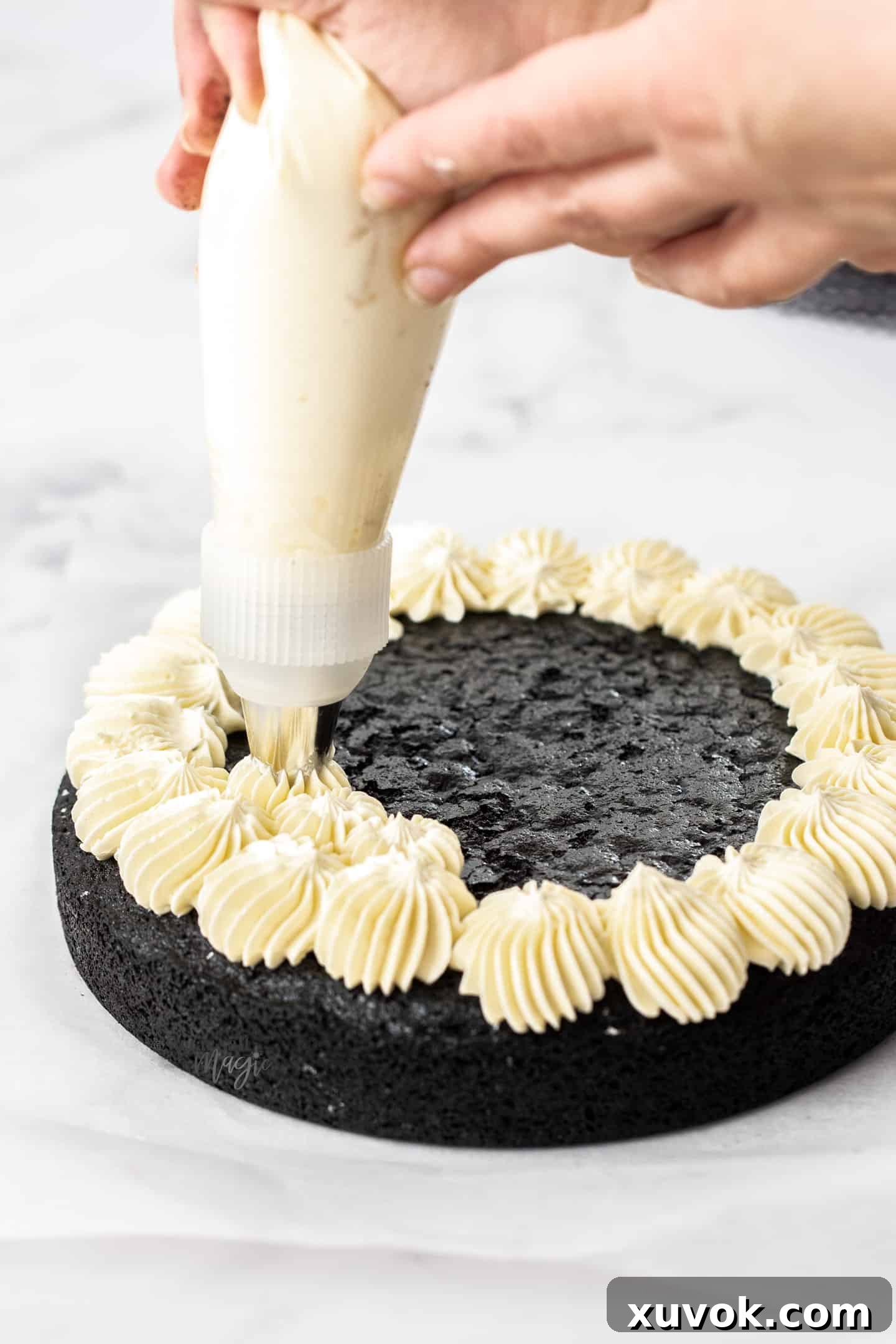 Swiss meringue buttercream being piped onto a cake.