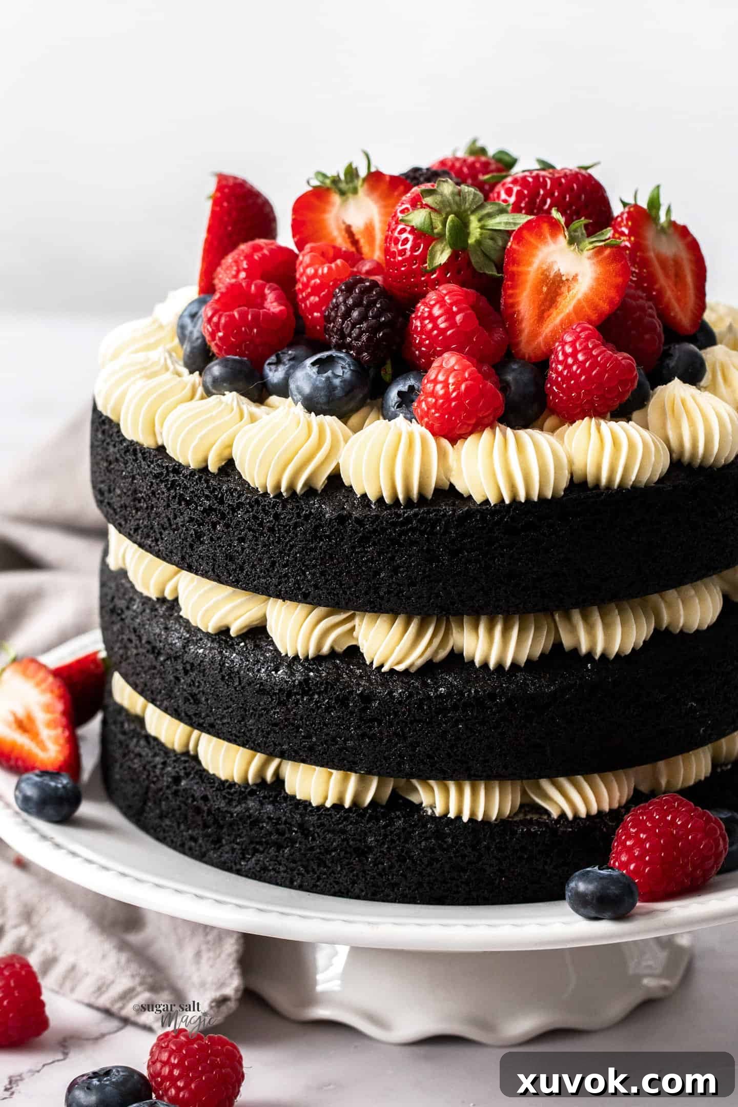 A 3 layer dark chocolate cake loaded with berries and white frosting.