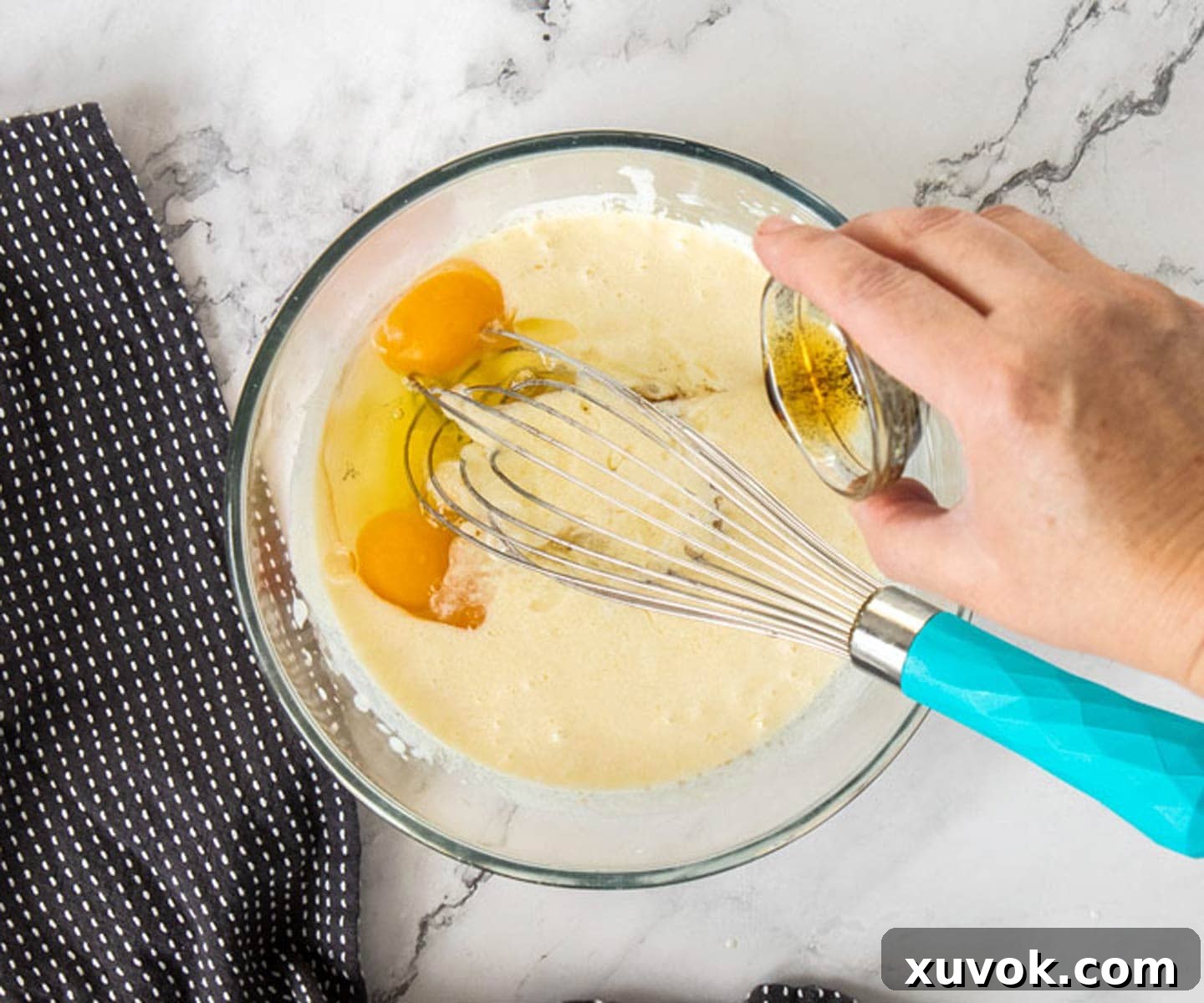 The wet ingredients for black velvet cake in a clear glass bowl, showcasing their smooth consistency.